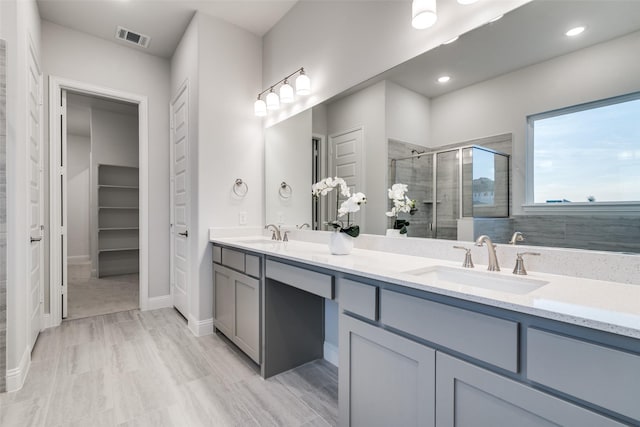 bathroom with vanity and a shower with shower door