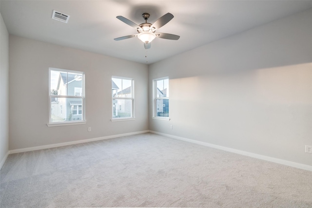 carpeted empty room featuring plenty of natural light and ceiling fan