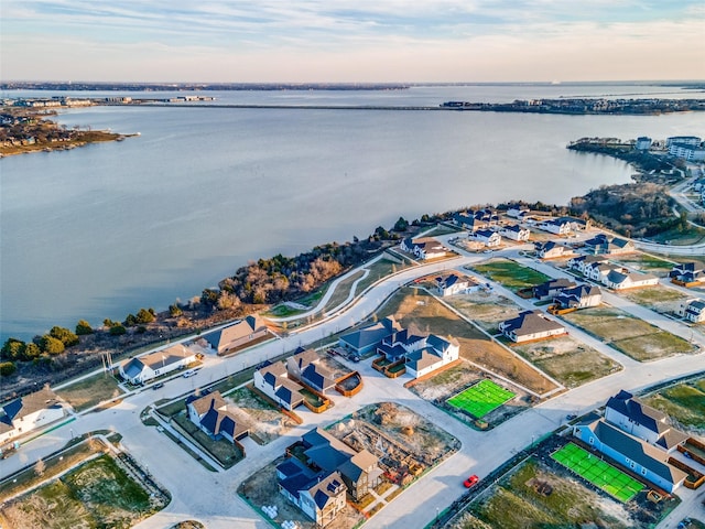 aerial view at dusk featuring a water view