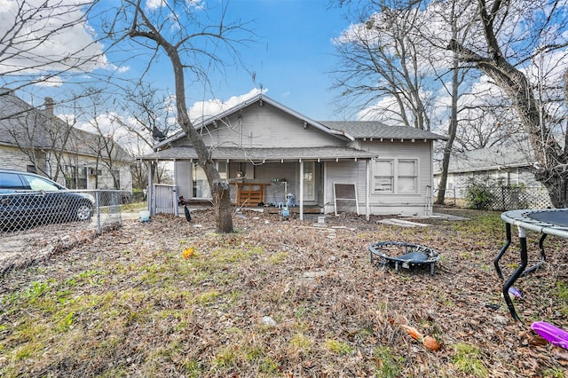 exterior space featuring a porch, a fire pit, and a trampoline