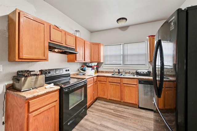 kitchen featuring sink, light hardwood / wood-style floors, and black appliances