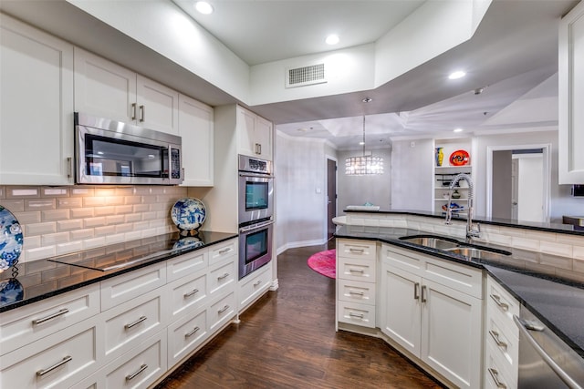 kitchen featuring white cabinetry, sink, tasteful backsplash, decorative light fixtures, and appliances with stainless steel finishes