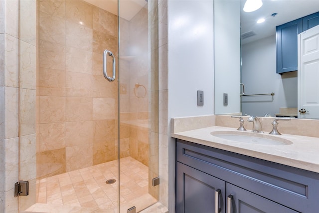 bathroom featuring a shower with door and sink