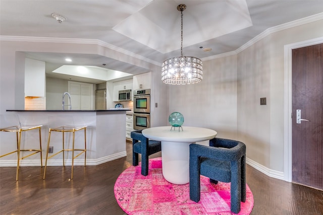 dining room with an inviting chandelier, crown molding, and a tray ceiling