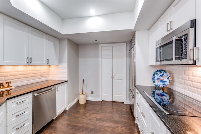 kitchen featuring decorative backsplash, white cabinetry, and stainless steel appliances