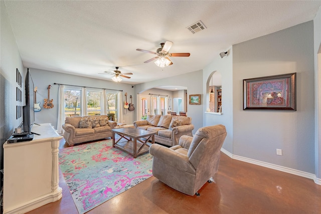 living room with ceiling fan, concrete flooring, and a textured ceiling