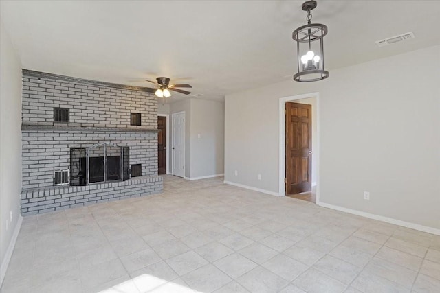 unfurnished living room with light tile patterned floors, ceiling fan with notable chandelier, and a brick fireplace