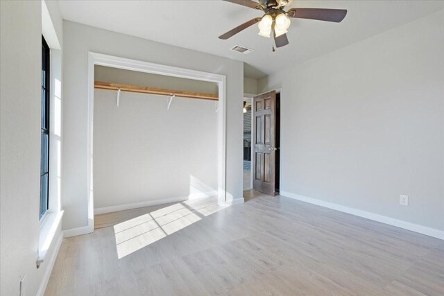 unfurnished bedroom featuring ceiling fan, a closet, and light hardwood / wood-style floors