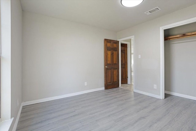 unfurnished bedroom with a closet and light hardwood / wood-style flooring