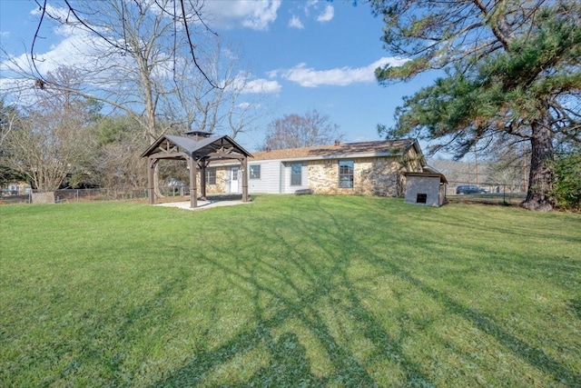 back of house featuring a gazebo and a lawn