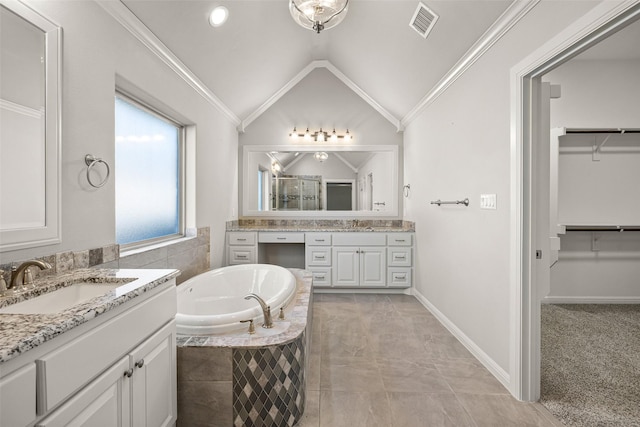 bathroom featuring tiled tub, vanity, ornamental molding, and vaulted ceiling