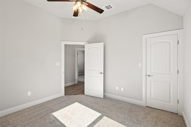 unfurnished bedroom with ceiling fan, lofted ceiling, and carpet flooring