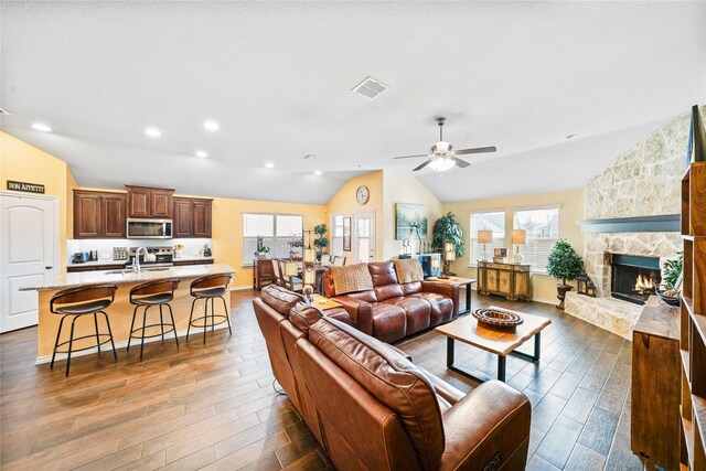 interior space with hardwood / wood-style floors, a breakfast bar, an island with sink, dark brown cabinetry, and stainless steel appliances