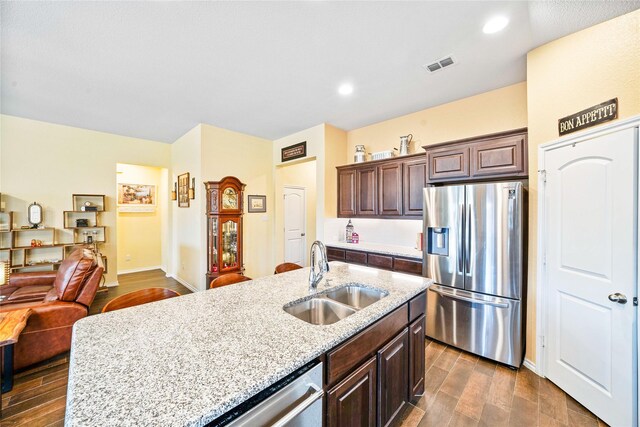 dining room featuring a stone fireplace, plenty of natural light, dark wood-type flooring, and vaulted ceiling