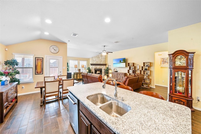 kitchen with appliances with stainless steel finishes, backsplash, a kitchen island with sink, sink, and dark hardwood / wood-style floors