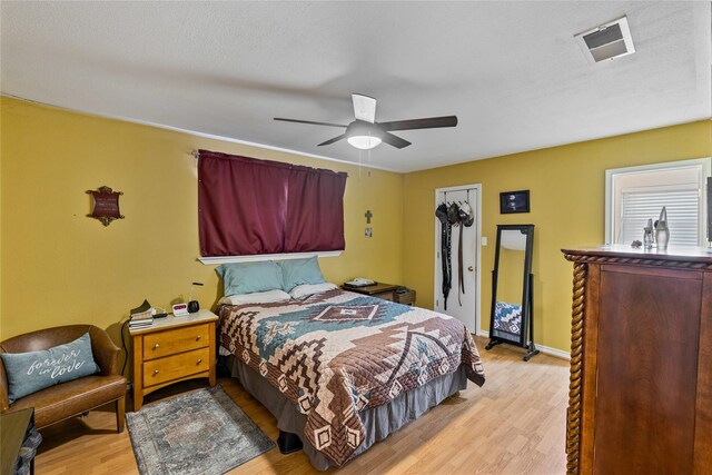 bedroom featuring ceiling fan, light hardwood / wood-style flooring, and a closet