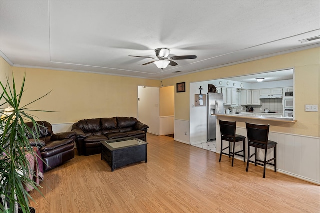 living room featuring ceiling fan and light hardwood / wood-style flooring