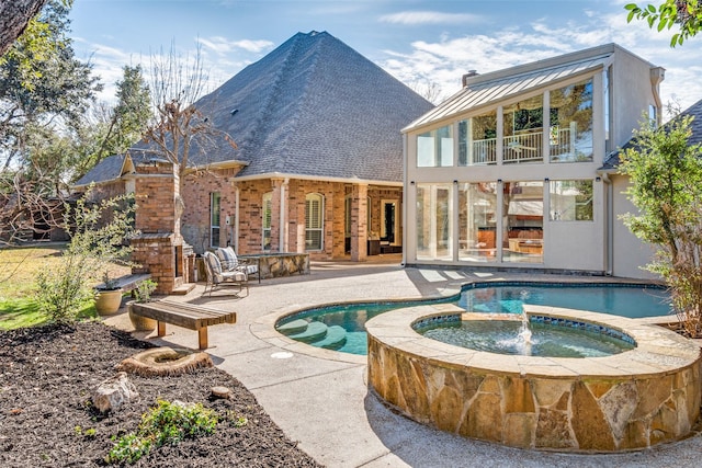 rear view of property featuring a swimming pool with hot tub, a patio, and a balcony