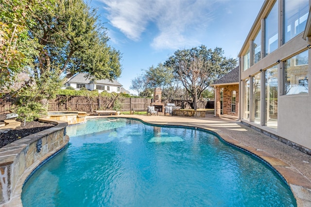 view of swimming pool featuring an in ground hot tub, a patio, and an outdoor stone fireplace