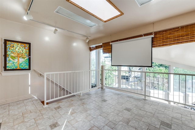 unfurnished room with rail lighting