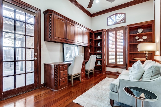 office with ceiling fan, plenty of natural light, dark hardwood / wood-style flooring, and built in desk