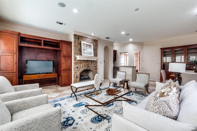 living room featuring ornamental molding and a stone fireplace