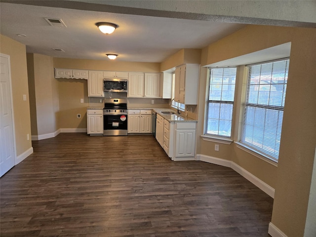 kitchen featuring appliances with stainless steel finishes, light stone counters, sink, white cabinets, and dark hardwood / wood-style floors