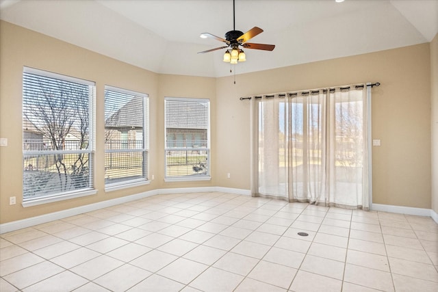 empty room with light tile patterned floors, a healthy amount of sunlight, and lofted ceiling