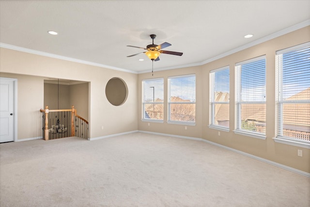 carpeted empty room with ceiling fan and ornamental molding