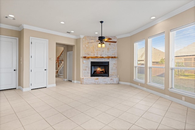 unfurnished living room with a fireplace, ornamental molding, ceiling fan, and light tile patterned flooring