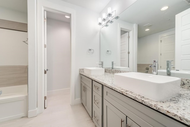 bathroom featuring tile patterned floors, vanity, and a washtub