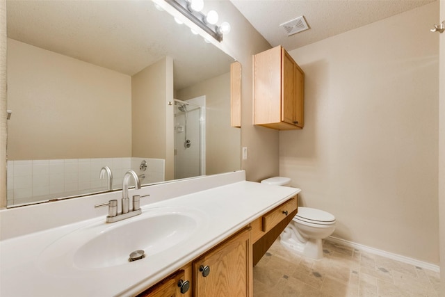 bathroom featuring vanity, toilet, a shower with shower door, and a textured ceiling