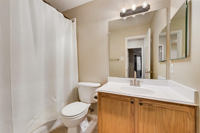 bathroom featuring a shower with curtain, vanity, toilet, and a textured ceiling