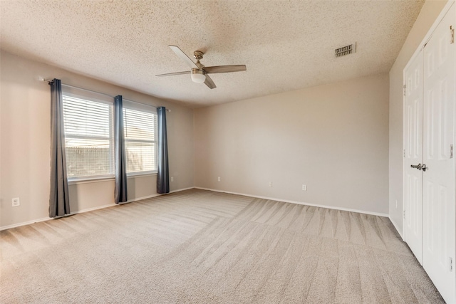 unfurnished room with light carpet, a textured ceiling, and ceiling fan