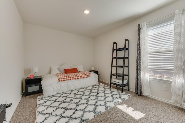 bedroom featuring light carpet and baseboards