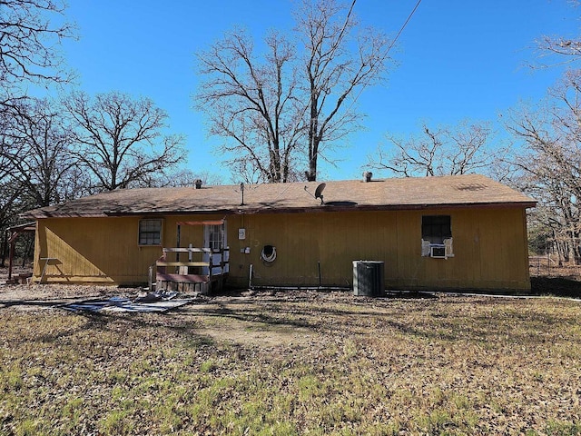 rear view of property with cooling unit and a lawn