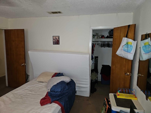 bedroom with concrete flooring, a textured ceiling, and a closet