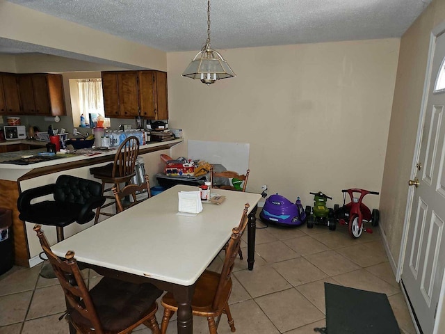 dining area with light tile patterned flooring and a textured ceiling