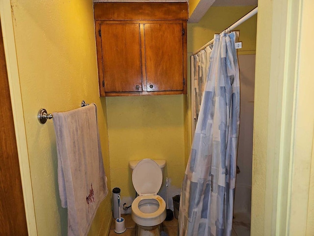 bathroom with tile patterned flooring, shower / bath combo, and toilet