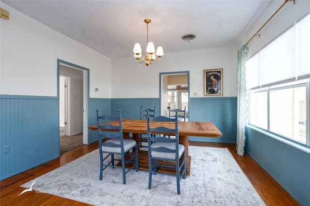 dining area featuring a wealth of natural light, dark hardwood / wood-style flooring, and a notable chandelier