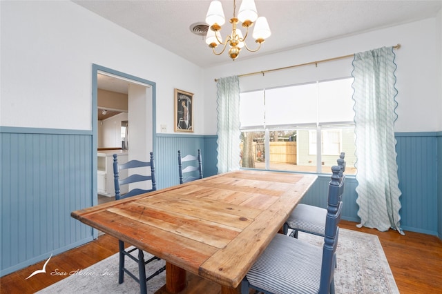 dining space with a notable chandelier and hardwood / wood-style flooring