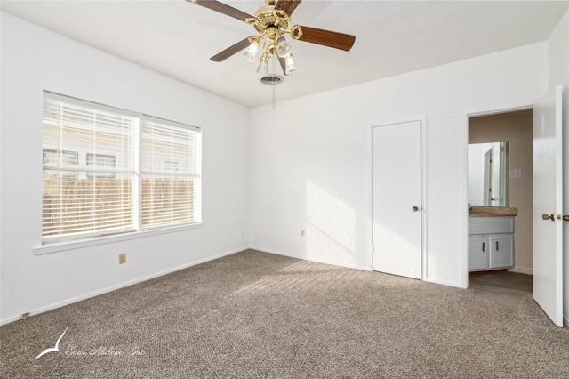 unfurnished bedroom with carpet, connected bathroom, a closet, and ceiling fan