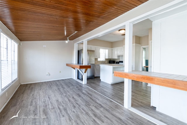 unfurnished living room with hardwood / wood-style flooring, plenty of natural light, wooden ceiling, and sink