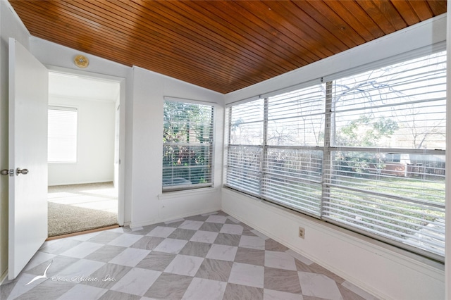 unfurnished sunroom featuring lofted ceiling, a wealth of natural light, and wooden ceiling