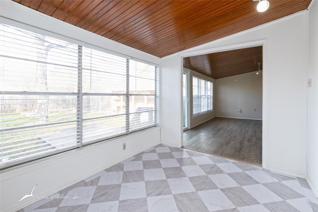 spare room featuring a healthy amount of sunlight, lofted ceiling, and wood ceiling