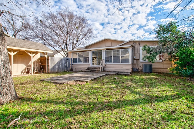 back of property with a yard, central AC, and a sunroom