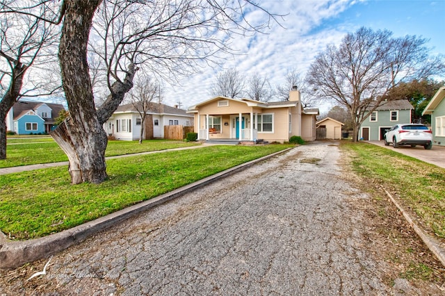 single story home featuring covered porch and a front yard