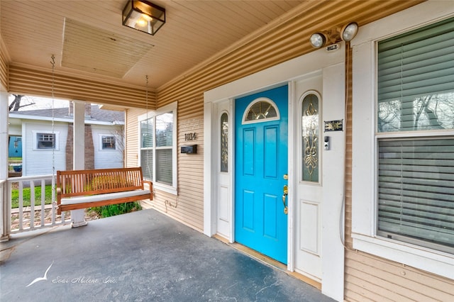 view of exterior entry featuring covered porch