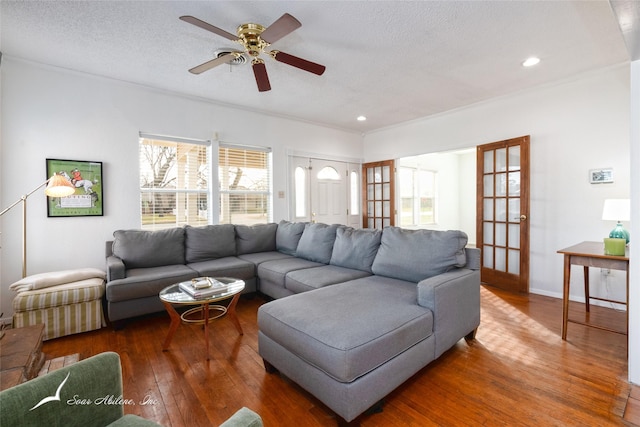 living room with ceiling fan, hardwood / wood-style floors, and a textured ceiling