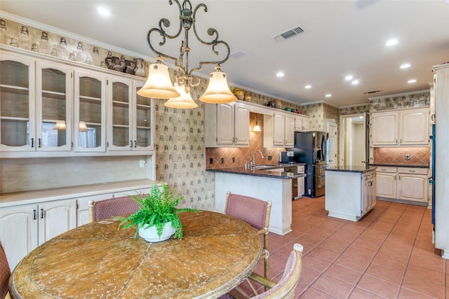 dining room with sink, light tile patterned floors, and ornamental molding